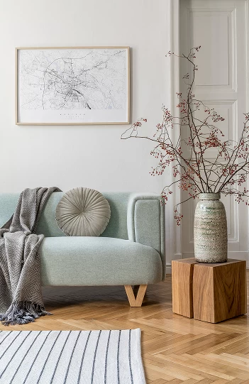 Détail d’un salon raffiné avec canapé pastel et vase décoratif en céramique à Montréal